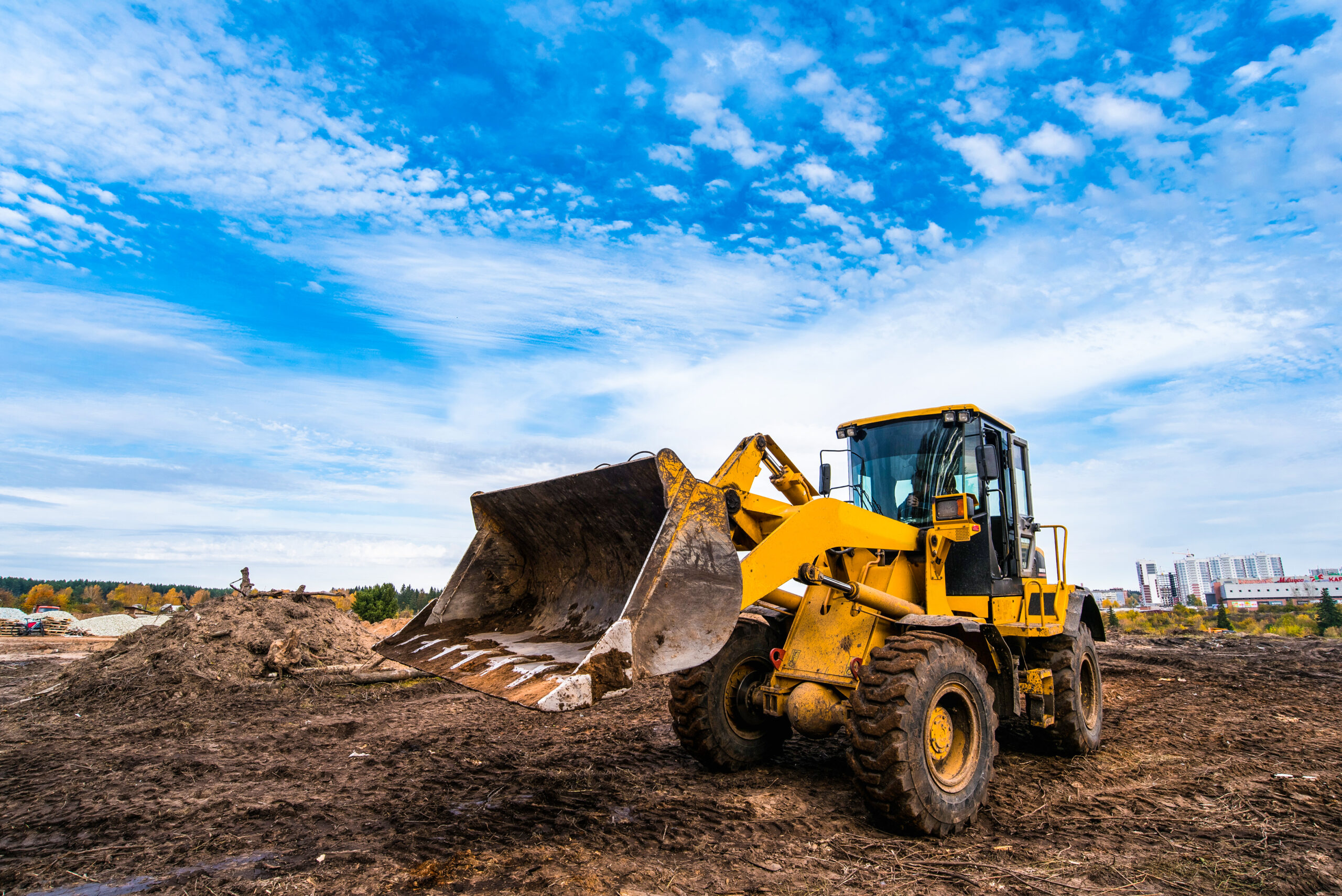 yellow-tractor-levels-ground-new-house-construction